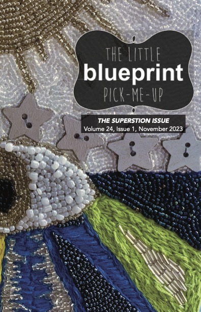 Cover of the superstition issue, featuring a close-up photo of a beaded artwork of and eye and stars.